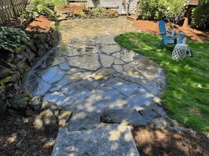 Irregular flagstone patio with random pattern layout in residential backyard