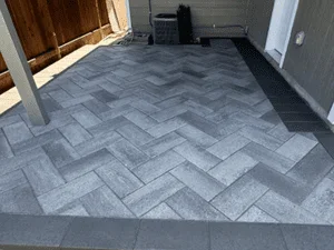 Gray concrete pavers in herringbone pattern with border edging