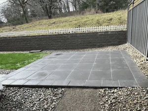 Slate paver patio with running bond pattern, gravel borders, and retaining wall