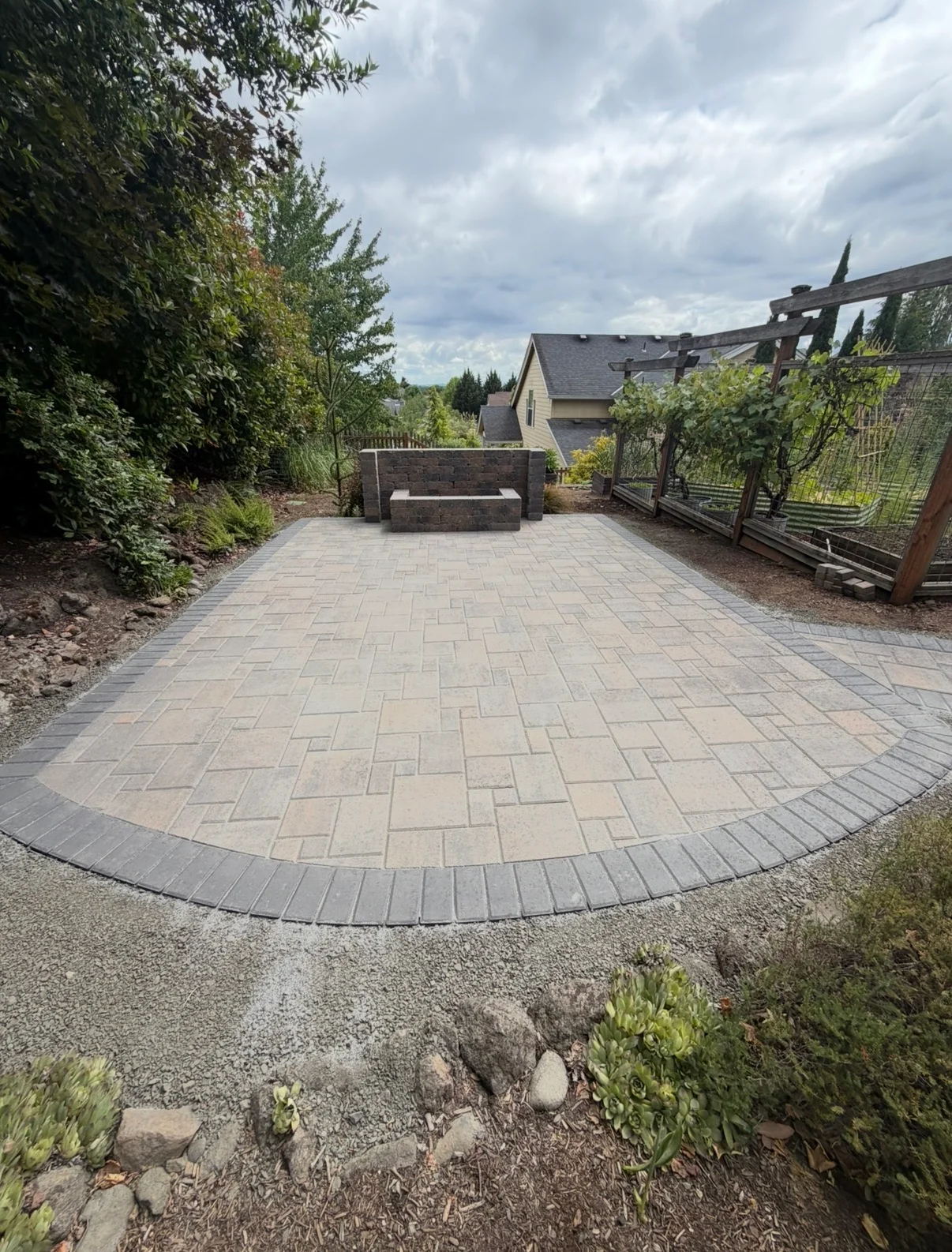 Beautiful circular paver patio with stone bench and garden surroundings in the Willamette Valley
